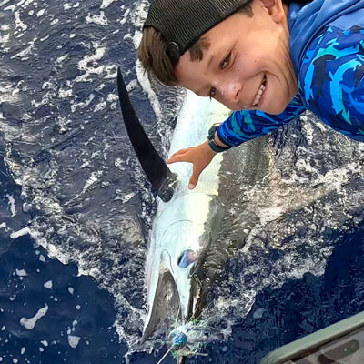 Blue Marlin next to the boat after being caught by angler on High Flier Sportfishing boat in Kona, Hawaii